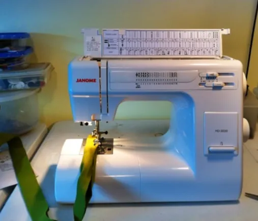 Original photo demonstrating the Janome HD3000 sewing six layers of folded denim; adjustable presser foot pressure dial is visible and set to the high setting for smooth stitching on heavy materials.