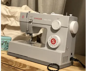 High-angle shot of the Singer Heavy Duty 4423 sewing machine, showing the clear Top Drop-In Bobbin System and the 23 built-in stitch selection dial.